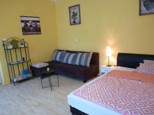 - un salon avec un lit et un canapé dans l'établissement Zizi Apartman, à Debrecen
