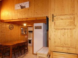 cocina y comedor con mesa y nevera en Demi-Chalet Le Bief --Prox pistes, en Les Carroz d'Araches