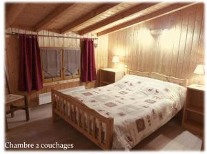 レ・キャローズ・ダラッシュにあるDemi-Chalet Le Bief --Prox pistesのベッドルーム1室(赤いカーテン付きの大型ベッド1台付)