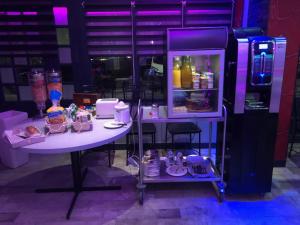 a small white table with a refrigerator in a room at L' Annexe Beverl'inn in Flers