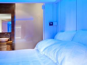 a bedroom with a white bed and a sink at De Dames Van De Jonge Hotel Restaurant in Giethoorn