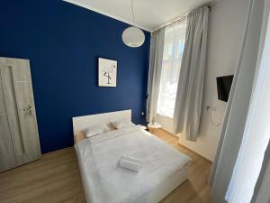 ein Schlafzimmer mit einer blauen Wand und einem Bett in der Unterkunft Apartamenty Stare Miasto in Bydgoszcz