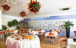 a dining room with tables and chairs with food on them at Hotel Master in Turin