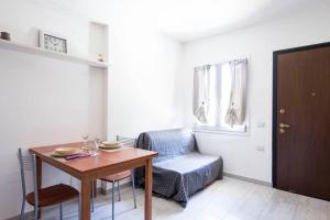 uma sala de estar com uma mesa e uma cadeira em Appartamento Lungomare em SantʼAntioco Ponti
