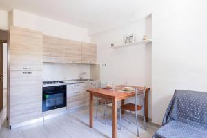 uma cozinha com uma mesa de madeira e um sofá azul em Appartamento Lungomare em SantʼAntioco Ponti