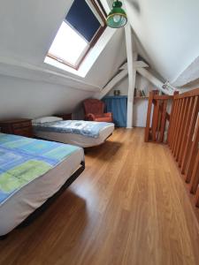 Un dormitorio abuhardillado con dos camas y una claraboya. en Welcome-to-Burgundy, en Nuits-Saint-Georges