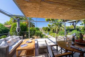 a patio with a couch and a table and chairs at MARILIA VILLAS LASSI in Lassi