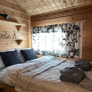 Cette chambre comprend un grand lit et une fenêtre. dans l'établissement Aurora mökki porealtaalla Lapissa Tenojoen rannassa, à Nuorgam