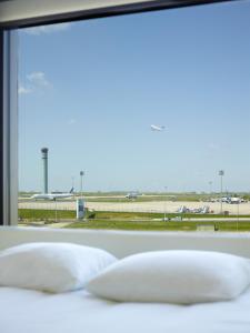 a view of an airport runway through a window at citizenM Paris Charles de Gaulle Airport in Roissy-en-France