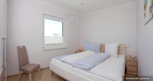 Schlafzimmer mit einem Bett, einem Fenster und einem Stuhl in der Unterkunft Ferienwohnung Steuerbord in Zinnowitz