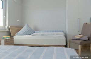 una camera da letto con un letto e una sedia di Ferienwohnung Bug a Zinnowitz Altre 14 foto