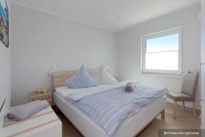 una camera bianca con un letto e una finestra di Ferienwohnung Bug a Zinnowitz