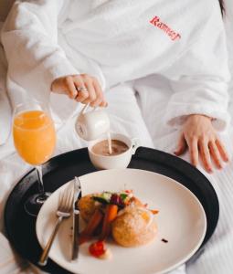 a person with a plate of food and a drink at Hotel Resort&Spa Kamelot in Kamenitsa