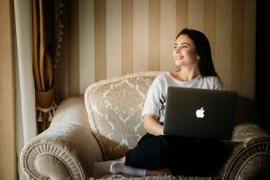 a woman sitting on a chair with a laptop at Kamelot in Kamenitsa