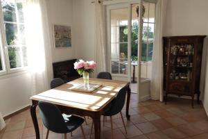 uma mesa de jantar com cadeiras e um vaso de flores em Suite Tropézienne em Saint-Tropez