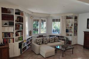 uma sala de estar com um sofá e prateleiras de livros em Suite Tropézienne em Saint-Tropez