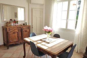 une table à manger avec des chaises et un vase de fleurs. dans l'établissement Suite Tropézienne, à Saint-Tropez 14 autres photos