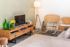 a living room with a television on a wooden table at Casa do Bago in São Vicente