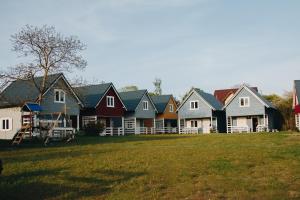 a row of houses sitting on a grass field at OSADA NA WYSPIE in Gdańsk