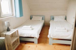 two twin beds in a small room with a table at OSADA NA WYSPIE in Gdańsk