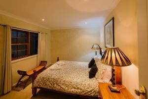 1 dormitorio con 1 cama y 2 lámparas en una mesa en Barrington Hideaway- River Cottages, en Gloucester