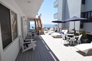 a balcony with chairs and umbrellas on a building at Malibu Private Beach Apartments in Malibu