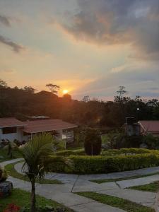 ein Sonnenuntergang über einem Haus mit Sonnenuntergang in der Ferne in der Unterkunft Finca Villa Elenita in Sasaima