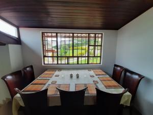 a dining room table with chairs and a window at Finca Villa Elenita in Sasaima