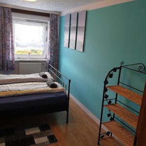 um quarto com uma cama com uma parede azul em Ferienwohnung/Norden/4Personen em Norden