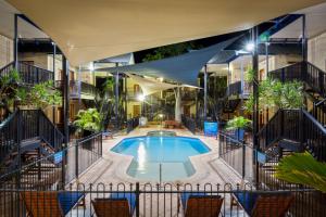 una piscina en medio de un edificio con sillas en Blue Seas Resort, en Broome