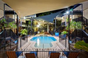 a swimming pool in the middle of a building with chairs at Blue Seas Resort in Broome