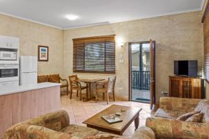 a living room with a couch and a table at Blue Seas Resort in Broome