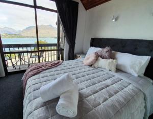 a bedroom with a large bed with a view of the water at Million dollar view in Queenstown