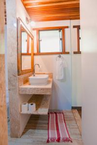 a bathroom with a sink and two windows at Pousada e Restaurante Mangue Seco Angra in Angra dos Reis