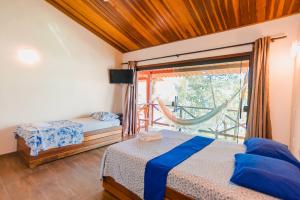 um quarto com uma cama e uma janela com uma rede de descanso em Pousada e Restaurante Mangue Seco Angra em Angra dos Reis