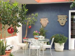 eine Terrasse mit einem Tisch, Stühlen und Pflanzen in der Unterkunft Casa Larrea Inn in Palm Desert
