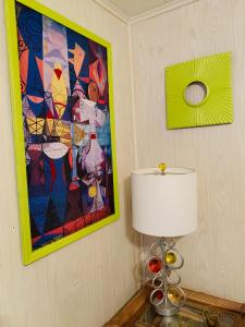 una lámpara en una mesa en una habitación con una pintura en El Hoy, en Tampa