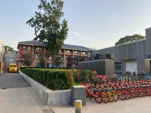 Spring Time Hostel في بكين: صف من الدراجات متوقفة أمام المبنى