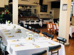 a group of tables in a restaurant with white tablecloths at Essex Arms in Huntly