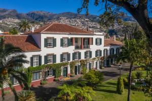 uma vista aérea de um grande edifício branco com persianas verdes em Quinta Jardins do Lago em Funchal