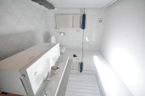 ラウターブルンネンにあるLuxury Penthouse Apartmentの白いバスルーム(洗面台2台、トイレ付)