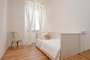 sypialnia z łóżkiem, krzesłem i oknem w obiekcie BELLAVISTA - Garda Leisure w mieście Salò