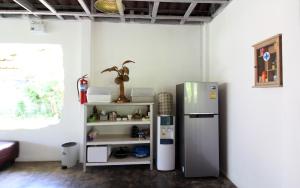 a kitchen with a refrigerator next to a shelf at Malee Malee Guesthouse in Ko Lanta