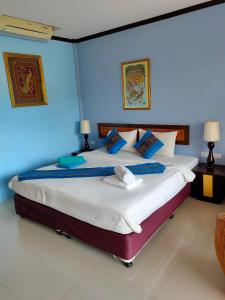 1 dormitorio con 1 cama grande y paredes azules en Grand Thai House Resort, en Lamai