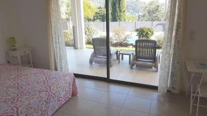 a bedroom with a bed and a patio with a table and chairs at villaserena83 in Toulon