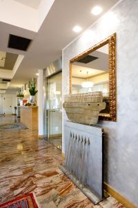 un espejo en la pared de un vestíbulo con un tazón en Hotel San Martino, en Darfo Boario Terme