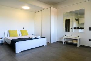 - une chambre avec un grand lit et un miroir dans l'établissement Minimal Studio in Nature, Exostis Nafplio, à Nauplie