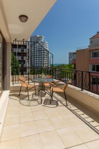 patio con mesa y sillas en el balcón en Apartments Flora 1, en Burgas