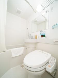 La salle de bains blanche est pourvue de toilettes et d'un lavabo. dans l'établissement Super Hotel Hida Takayama, à Takayama