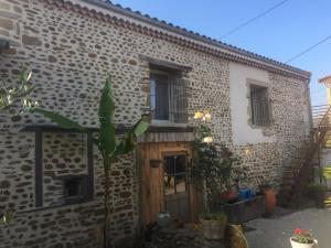 Casa de piedra con puerta de madera en un patio en Ô Joly Valois en Hauterives